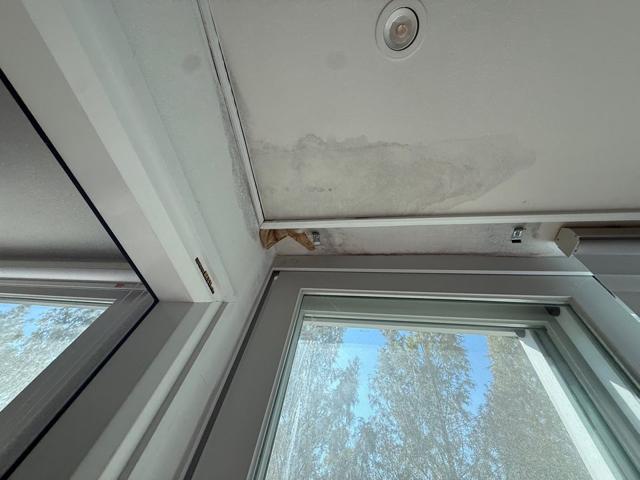 아랫집 거실 창가 모서리 천장. 샷시 옆으로 젖은 자국