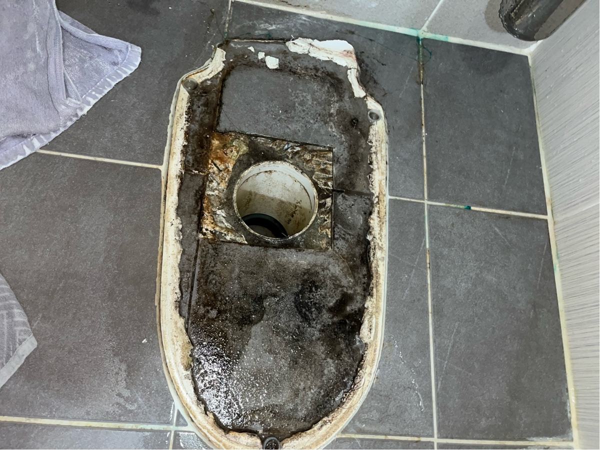 변기를 들어낸 자리. 둘레로 물이 고여 찌든 자국이 있었습니다